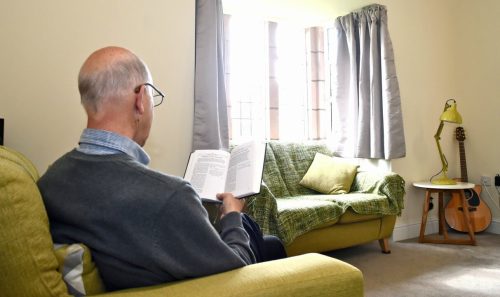Resident reading in the lounge of a larger cottage