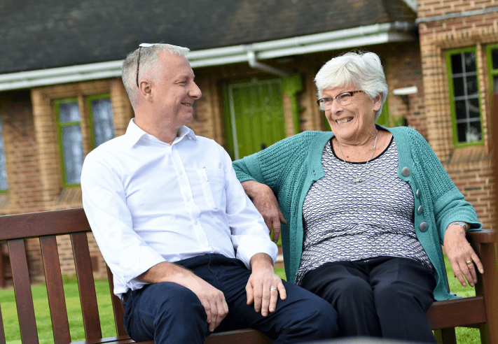 Scheme manager and resident chatting on bench